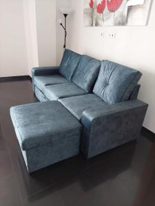 a living room with a blue couch and stool at Rocha Tower Apartments in Portimão