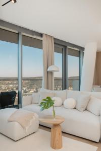 a living room with a white couch and large windows at Wave - Sea View Resort&SPA E11112 in Międzyzdroje +36 photos