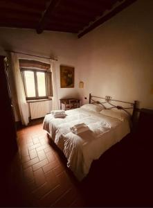 una camera da letto con un grande letto bianco e una finestra di LOCANDA PODERE LE VIGNE a Radda in Chianti
