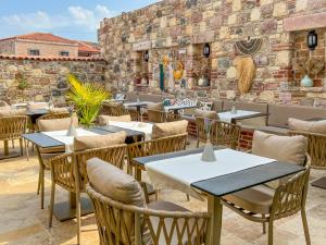 a restaurant with tables and chairs and a brick wall at PARLA KÜÇÜKKÖY in Ayvalık