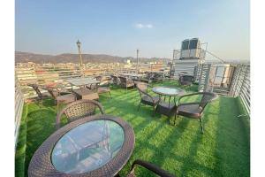 einen Balkon mit Tischen, Stühlen und einem Spiegel in der Unterkunft Hotel Jaipur Dreams in Jaipur