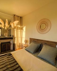 Schlafzimmer mit einem Bett, einem Kamin und einem Spiegel in der Unterkunft MAISON 54 in Bernay
