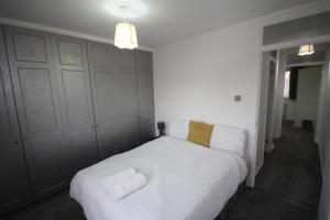 een slaapkamer met een wit bed met 2 kussens bij Lee's Lodge - Modern 2 Bedrooms in Hillingdon