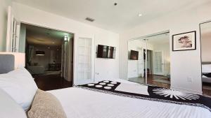 a bedroom with a large white bed and a mirror at The Lofts on Clematis 402 Downtown West Palm Beach in West Palm Beach