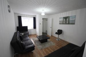 een woonkamer met een bank en een tafel bij Lee's Lodge - Modern 2 Bedrooms in Hillingdon