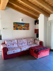 a living room with a red couch and a red ottoman at River House in Porlezza