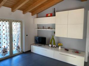 a living room with white cabinets and a television at River House in Porlezza