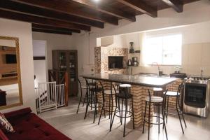 a kitchen with a counter and a bar with stools at Amplo apto próximo a Praia in Garopaba