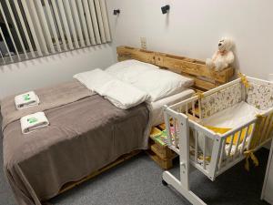 a bedroom with a twin bed and a crib at Apartamenty Kajetany 3Rooms in Kajetany