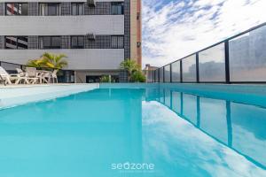 マセイオにあるApto com piscina bem localizado em Maceió LTS1003の建物の前の青い水のスイミングプール