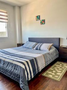 - une chambre dotée d'un lit avec une couverture bleue et blanche dans l'établissement Acogedor departamento en el centro de Cochabamba, à Cochabamba