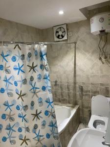 a bathroom with a toilet and a shower curtain with starfish at شقق 5د من الحرم النبوي Apartments 5mins near Masjid Nabawi in Al Madinah