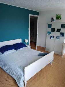 a bedroom with a large bed with a blue wall at Gîte à Châtelus, au calme dans l'Allier in Châtelus