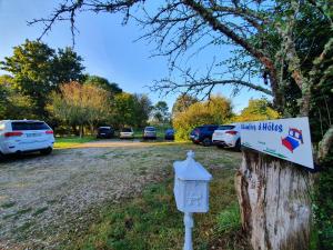 um sinal numa árvore ao lado de um parque de estacionamento em Ferme équestre & Chambres d'hôtes Gateau Stables proche Guédelon em Saint-Amand-en-Puisaye