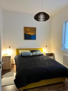 a bedroom with a large black bed with two lamps at Bonvenon in Szombathely