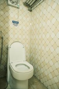 a bathroom with a toilet with a sign on the wall at Central Cozy apartment - Beer street 201#301 in Hanoi