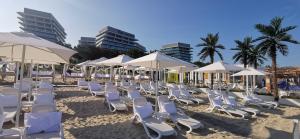 a bunch of chairs and umbrellas on a beach at Wave Family Luxury Apartment D973 in Międzyzdroje