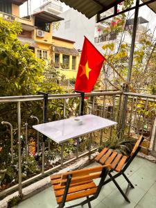 a table and chair with a flag on a balcony at Central Cozy apartment - Beer street 201#301 in Hanoi