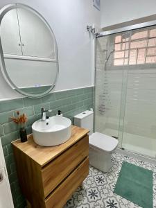 a bathroom with a sink and a mirror and a toilet at Acogedor apartamento enfrente de la catedral in Tarragona
