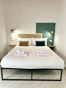 a bedroom with a large bed with two towels on it at 4Rooms in Palermo