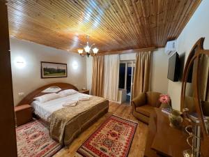 - une chambre avec un lit, un canapé et une télévision dans l'établissement Garden Villa Guni, à Krujë
