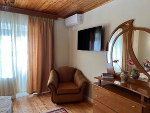 a living room with a chair and a mirror at Garden Villa Guni in Krujë