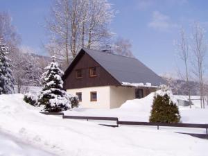 Casa blanca y marrón con nieve en el suelo en Chalupa František Filipovice, en Filipovice