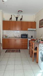 - une cuisine avec des placards en bois et une table avec un évier dans l'établissement DINAS Apartment Flogita Beach, à Flogita