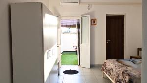 - une chambre avec un lit et une porte donnant sur une cour dans l'établissement Villetta Giuseppe CASA VACANZE NEL SALENTO, à San Foca