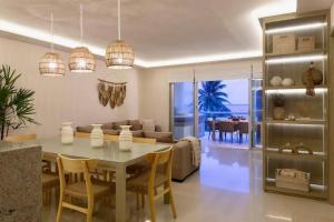 Un comedor y una sala de estar con mesa y sillas. en Seaside Sanctuary with Private Beach & Pool, en Playa del Carmen