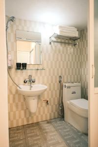 a bathroom with a sink and a toilet and a mirror at Central Cozy apartment - Beer street 201#301 in Hanoi