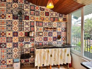 a kitchen with a wall covered in colorful tiles at Central Cozy apartment - Beer street 201#301 in Hanoi