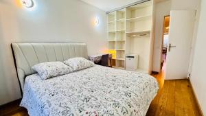 una camera da letto con un grande letto bianco con cuscini di Sweet home near Paris with Eiffel Tower view & 1 cozy private room or entire apartment with 3 rooms a Courbevoie