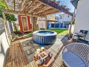 a hot tub sitting on a patio with two chairs at Cosy Tiny centre-ville de Nîmes in Nîmes