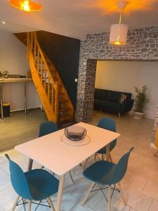 QuaroubleにあるAgréable maison avec parking gratuitのリビングルーム(テーブル、椅子付)