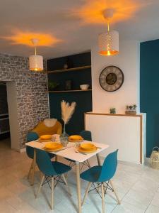 QuaroubleにあるAgréable maison avec parking gratuitのダイニングルーム(白いテーブル、青い椅子付) +8枚の写真
