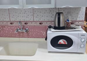 a microwave on top of a counter in a kitchen at نور المنازل للوحدات السكنية in Qarār