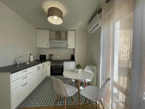 a kitchen with a white table and chairs and a table at Casa Albillo in Tudela