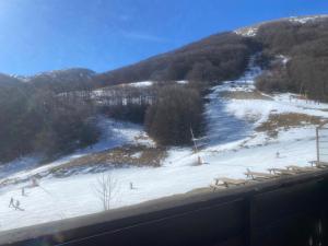 a snow covered slope with people skiing on a mountain at Al Colle in Ateleta