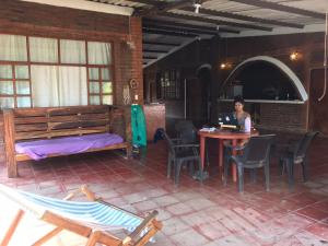 a woman sitting at a table with a laptop at Casa Vieja Surf Spa Mizata in La Libertad