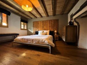 a bedroom with a large bed with a wooden headboard at Résidence Stone Shed - 5 Pièces pour 8 Personnes 981 in Saint-Marcel