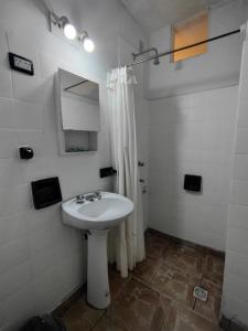 biała łazienka z umywalką i prysznicem w obiekcie Hotel Ery Noa w mieście San Salvador de Jujuy