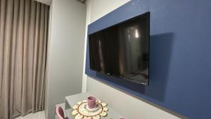 14- Studio decorado com ótima localização!!! في كوريتيبا: غرفة مع تلفزيون على جدار مع طاولة