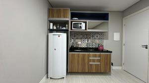 a kitchen with a refrigerator in a room at 14- Studio decorado com ótima localização!!! in Curitiba