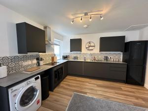 a kitchen with a washer and a washing machine at Surprise sea view cosy apartment in Morecambe