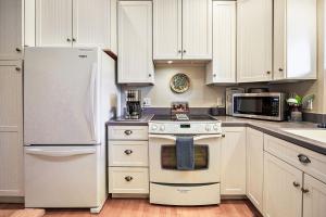 uma cozinha com armários brancos, um fogão e um frigorífico em Hanna's House by WanderLodges em Ashland