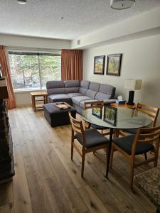 a living room with a couch and a glass table at Rocky Mountain Getaway in Canmore