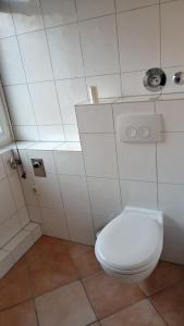 ein Bad mit einem weißen WC in einem Zimmer in der Unterkunft Apartment Klingemann in Hannover