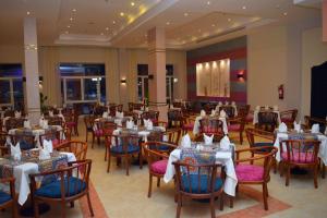 MG Alexander The Great Hotel في مرسى علم: غرفة طعام مع طاولات وكراسي في مطعم