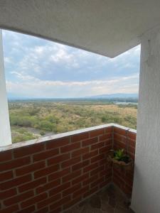 Habitación con pared de ladrillo y ventana en VIWI aparta suits con asombrosa vista al valle del río magdalena, en Dujos